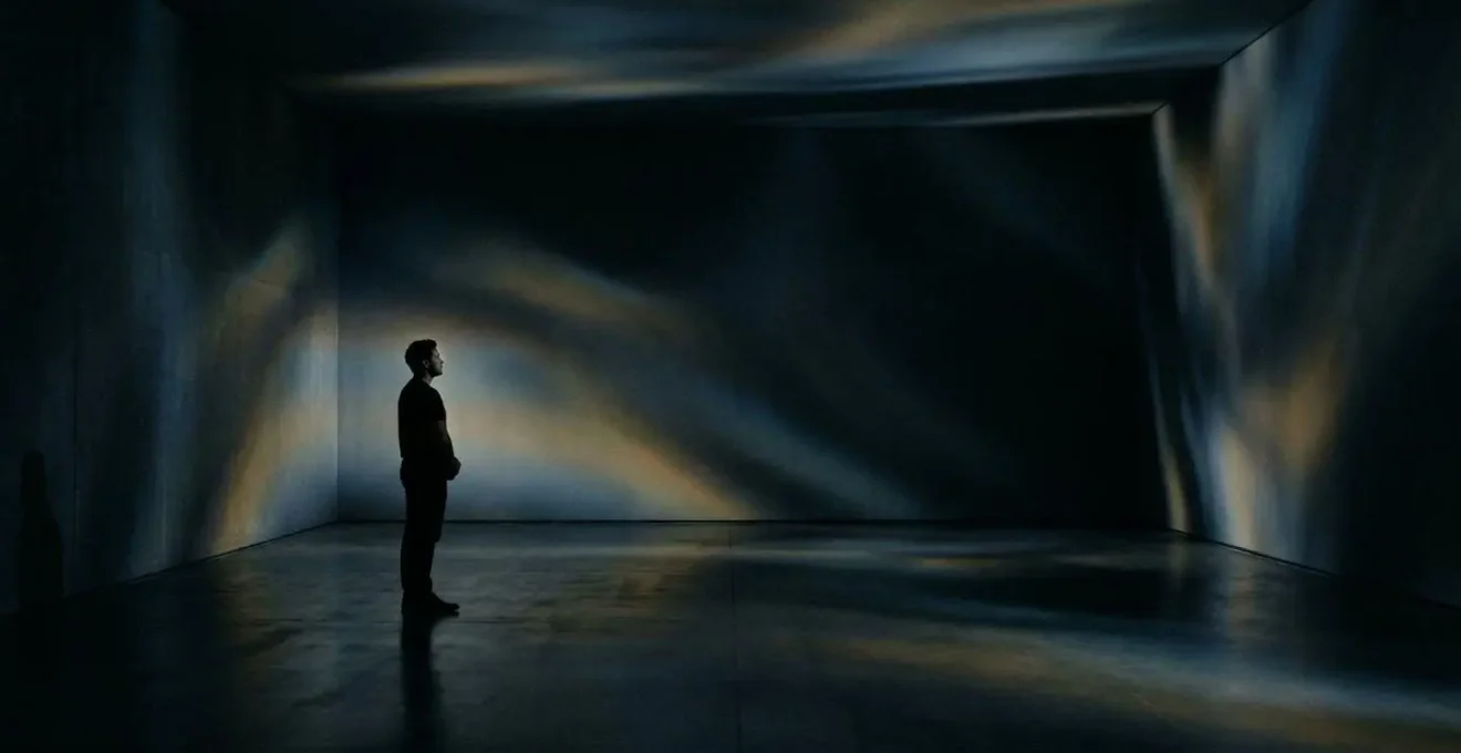 Installation artistique immersive avec projection lumineuse et spectateur en contemplation