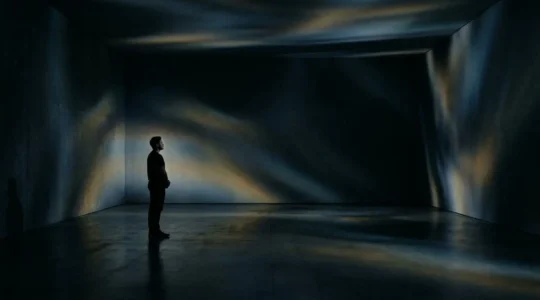 Installation artistique immersive avec projection lumineuse et spectateur en contemplation